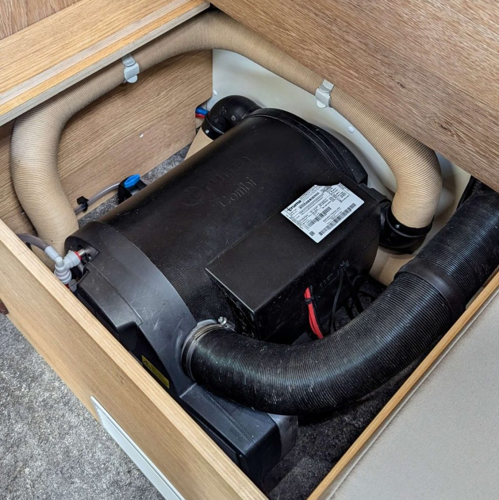Chauffage Truma Combi installé dans le mobilier d’un fourgon aménagé